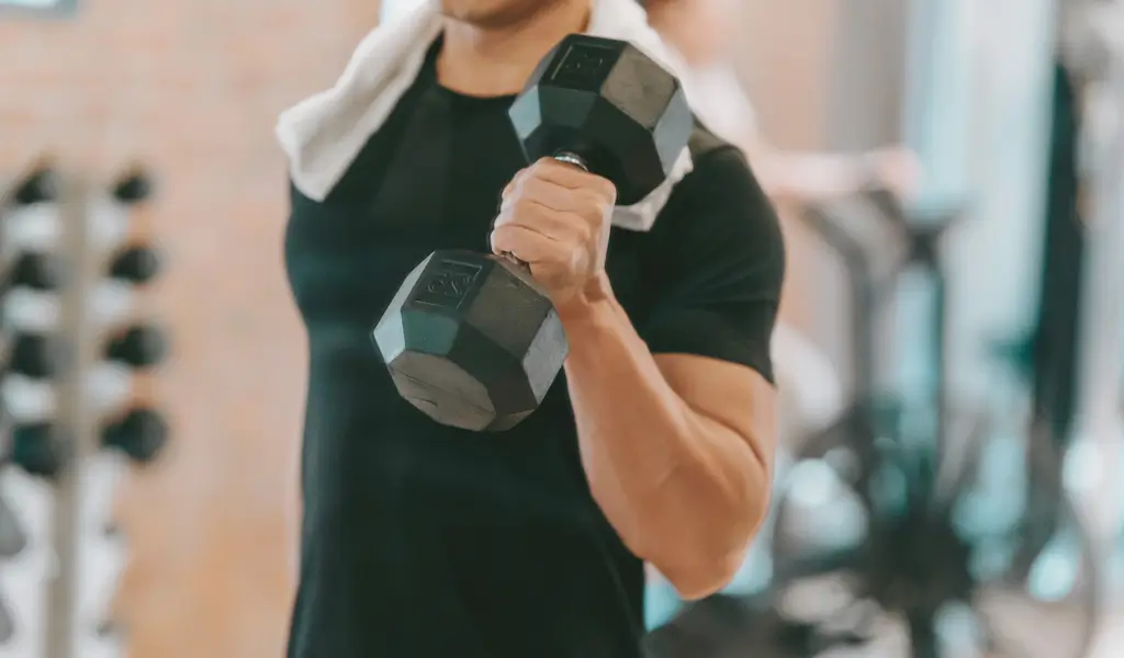 Mężczyzna w sportowej koszulce kompresyjnej podczas treningu na świeżym powietrzuMężczyzna w sportowej koszulce kompresyjnej podczas treningu na siłowni